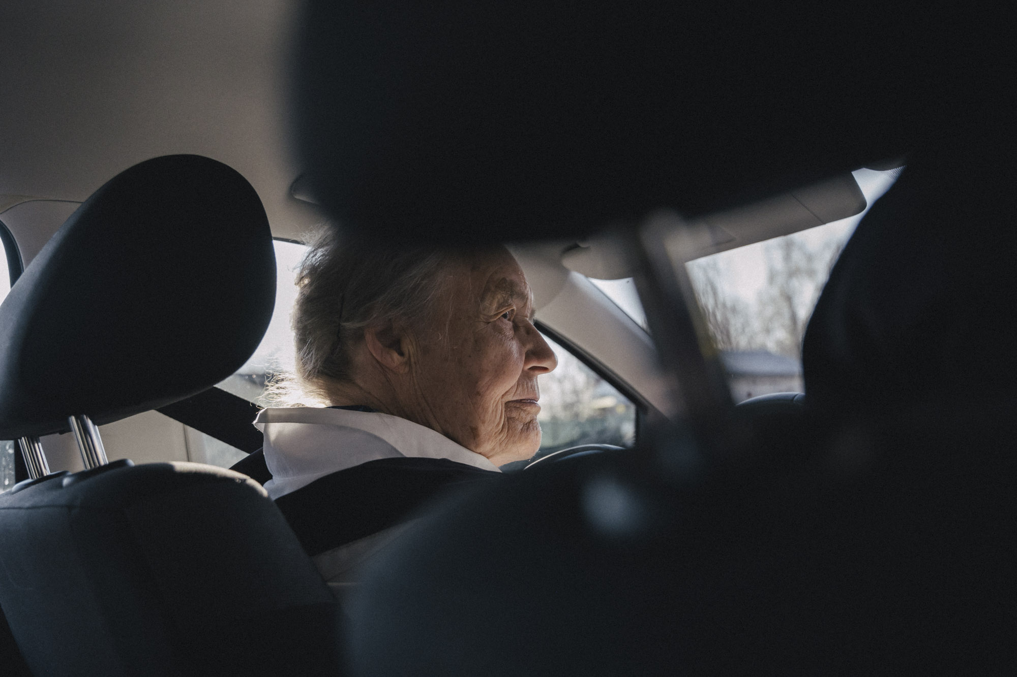 Eine Seniorin fährt einen Pkw.